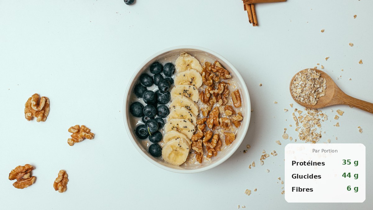 Bol de porridge protéiné chaud garni de banane, cacao et éclats d'amandes sur un plan de travail en bois