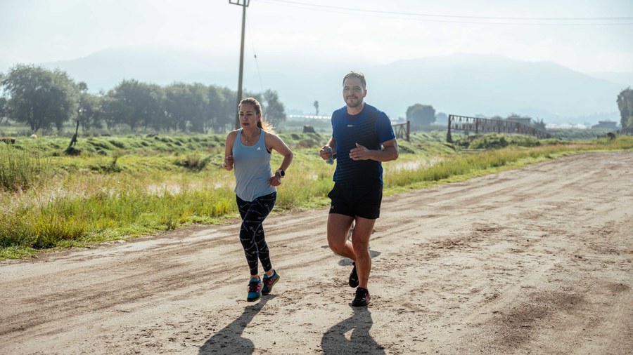 Coureur regardant sa montre GPS pendant une séance à allure marathon