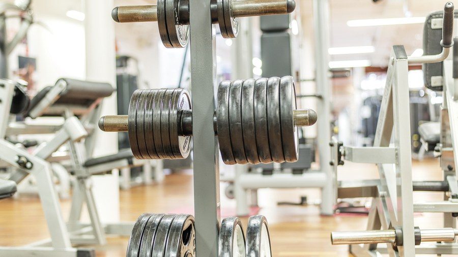 Homme effectuant un développé couché avec barre olympique en salle