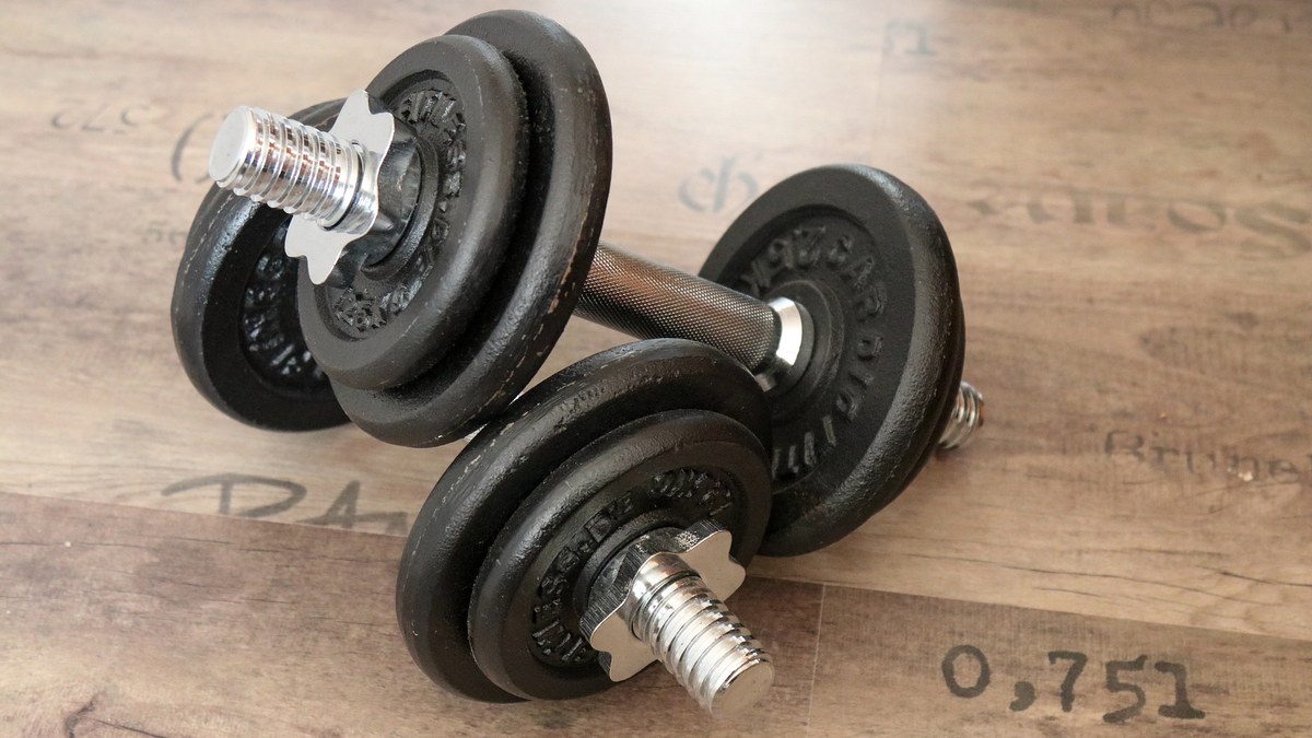 Homme musclé en débardeur faisant du soulevé de terre en salle de sport