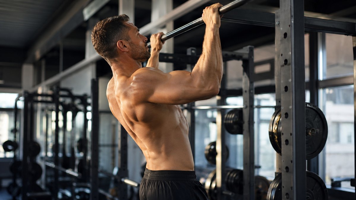 Sportif en pleine séance de tractions en salle de sport, split upper lower 4 jours